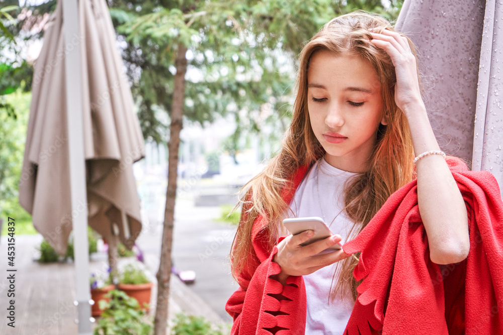 Fototapeta premium Pretty girl outdoors. Caucasian real people using mobile phone. Single female person. Staycation ecology concept. Positive attractive human portrait