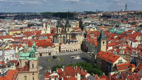 Prague beautiful panoramic sunny aerial drone view above Prague Old Town Square with Church of Our Lady before Tyn and Prague Astronomical Clock Tower. Drone flight over red roofs of Prague, Czechia. photo