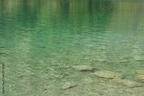 a full frame of a clear lake water with stones under water