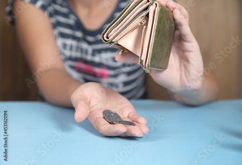woman holding wallet and coins
