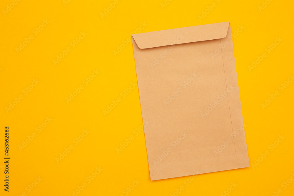 brown envelope front and back isolated on yellow background. View from the letter. brown envelope front and back isolated on yellow background. View from the letter.