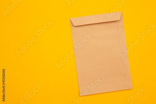 brown envelope front and back isolated on yellow background. View from the letter.