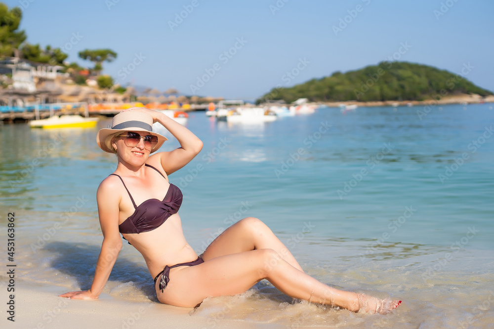 Smiling beautiful woman sunbathing on a beach