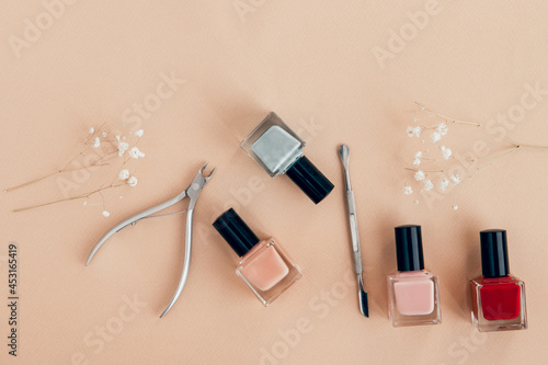 nail polish and manicure tools on beige background flat lay photo