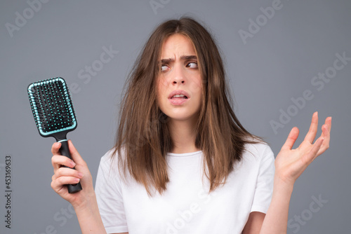 Woman with hair loss problem. Portrait of Young girl with a bald. Head shot of a nervous girl with a hairbrush.