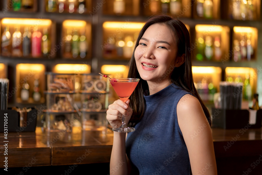Portrait of beautiful woman is drinking cocktail and having enjoy to relaxing while sitting alone to listening music