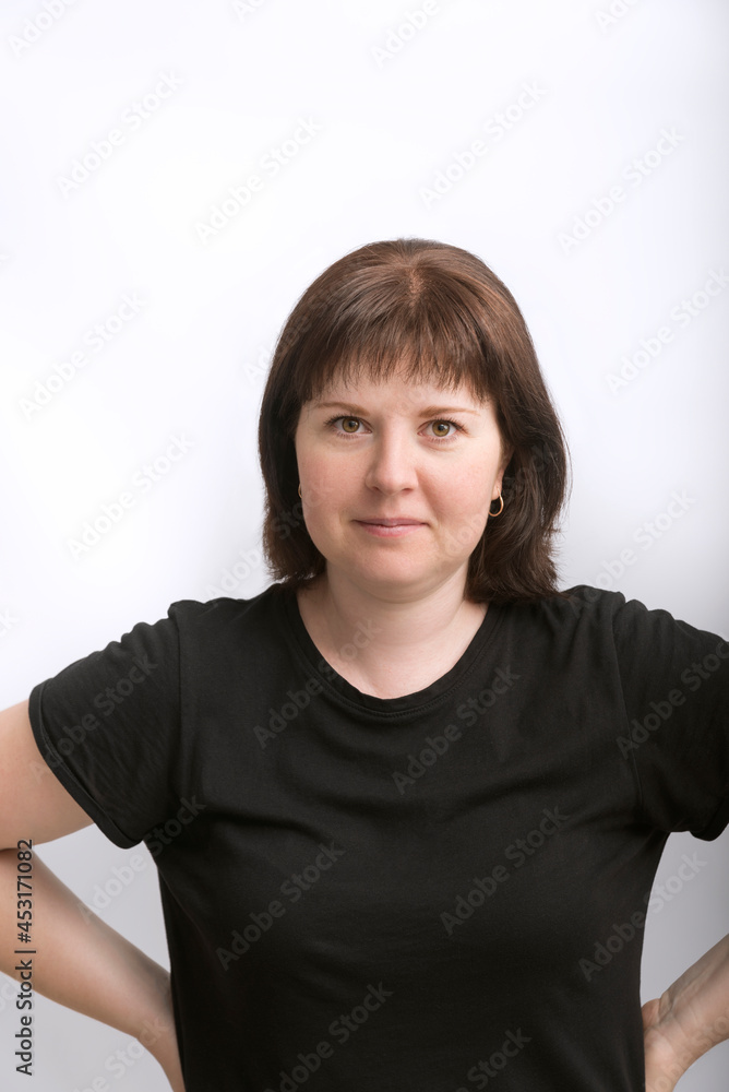 Portrait of middle aged woman in black T-shirt on white background. Woman with round face shape and hairstyle. Portrait of middle aged woman in black T-shirt on white background. Woman with round face shape and hairstyle.