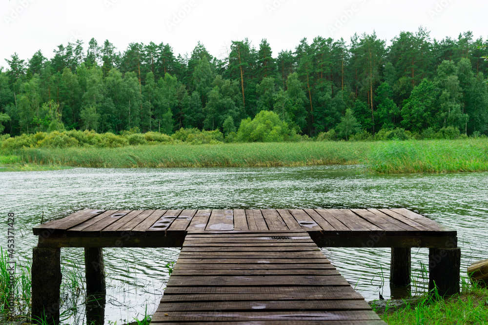 Pier on the lake in summer. Lake fishing pier Pier on the lake in summer. Lake fishing pier