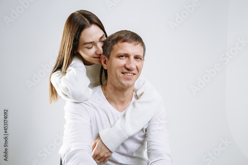 couple in love hugs on a light solid background