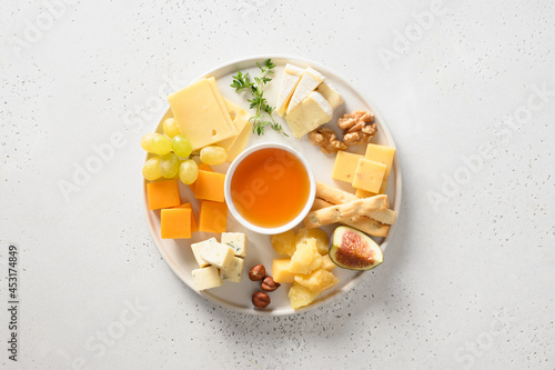 Slika na platnu Cheese platter with grapes, nuts, figs on a white background