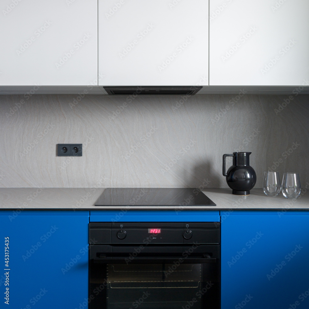 Fototapeta premium Black oven and induction hob in minimalist kitchen, close-up