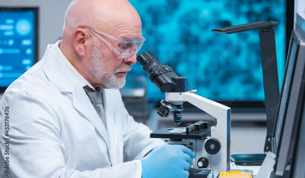 Professor works in a modern scientific laboratory using equipment and computer technologies. The scientist does research and develops new vaccines. Science and healthcare concept. Professor works in a modern scientific laboratory using equipment and computer technologies. The scientist does research and develops new vaccines. Science and healthcare concept.