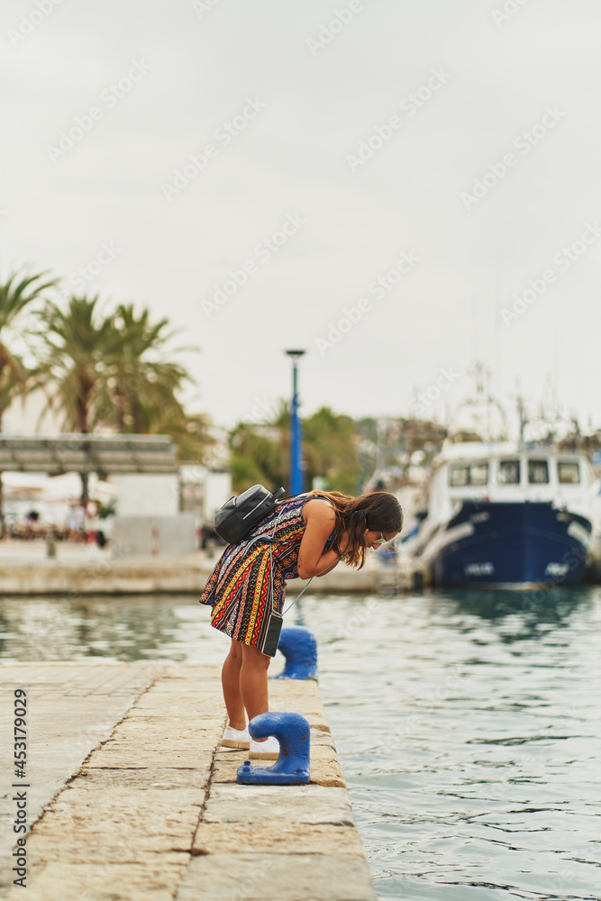 Young spanish woman checking harbour water