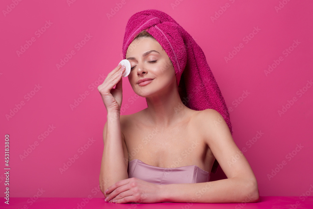 Young woman enjoys spa procedures, wrapped towel on head, isolated on studio background. Morning time, hygiene. Beautiful woman with perfect skin after beauty treatment. Young woman enjoys spa procedures, wrapped towel on head, isolated on studio background. Morning time, hygiene. Beautiful woman with perfect skin after beauty treatment.