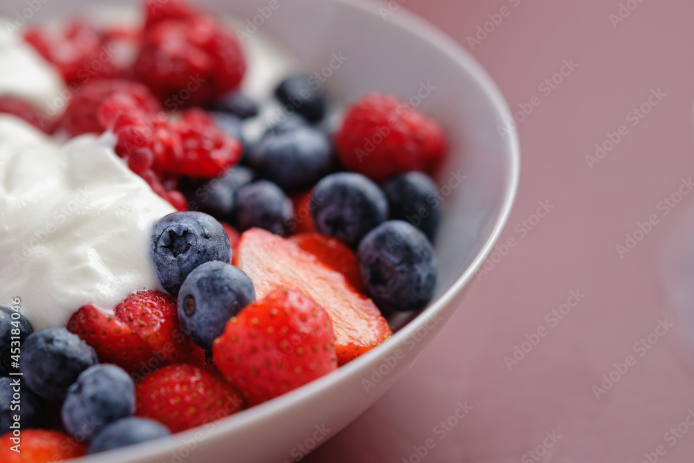 Red berry fruits and blueberries with yogurt, served in a bowl Red berry fruits and blueberries with yogurt, served in a bowl