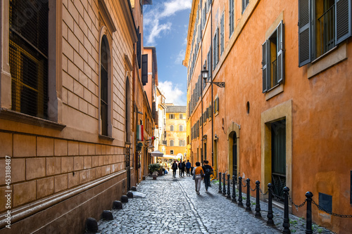 Canvas Print A colorful cobbled alley leading to a small piazza with outdoor cafe in the historic, centro storico section of Rome, Italy