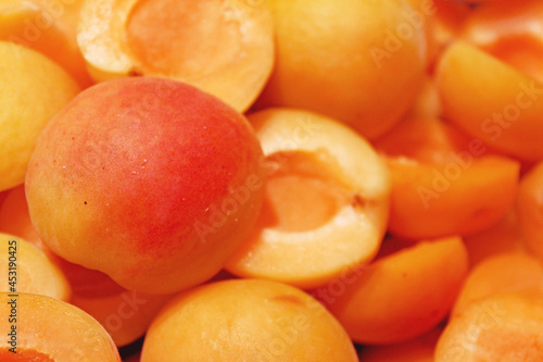 Texture of delicious bright juicy orange with red color ripe apricot. Background of halves fruit peach, without seeds kernels closeup. Harvest south berries preparation for jam. Place for text. 