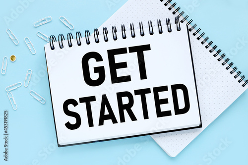 GET STARTED CONCEPT, text on white notepad paper on blue background