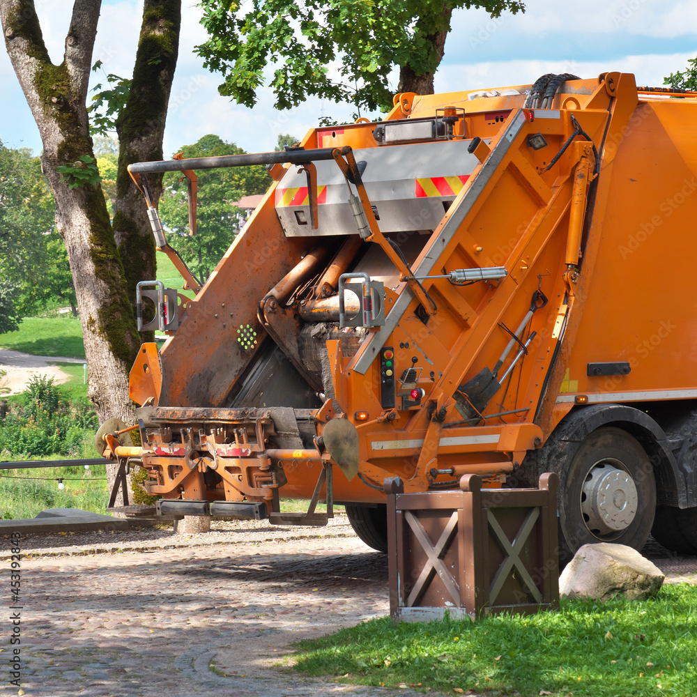 Orange garbage truck for removal of household waste.