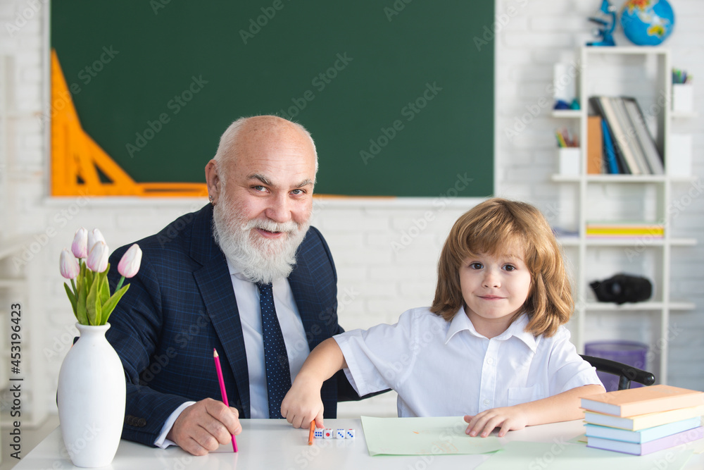 Cute young child in class at school. Senior teacher and at home working. Happy family old grandfather and grandson learning. Elderly teacher trainer teen pupil boy. Cute young child in class at school. Senior teacher and at home working. Happy family old grandfather and grandson learning. Elderly teacher trainer teen pupil boy.