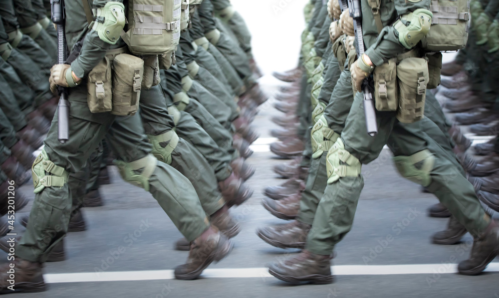 The soldiers' legs are dressed in ankle boots and camouflage pants. The soldiers' legs are dressed in ankle boots and camouflage pants.
