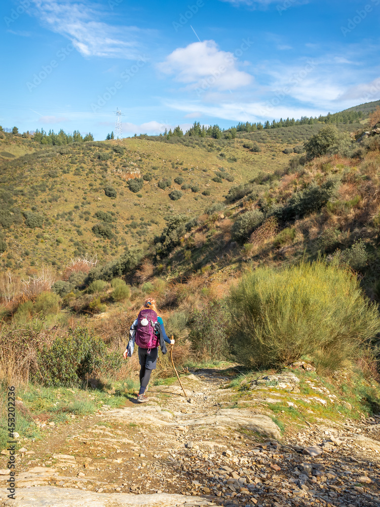 Pilgrim Girl Hiking down a Hill outside Molinaseca Spain along the Way of St James Pilgrimage Trail Camino de Santiago