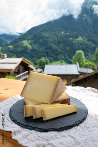 Cheese collection, French cow cheese comte, beaufort, abondance and french mountains village in Haute-Savoie on background photo