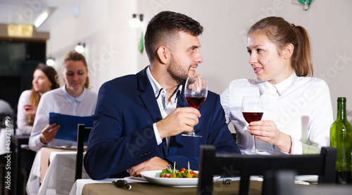Romantic couple is having dinner in the restaurante indoor.