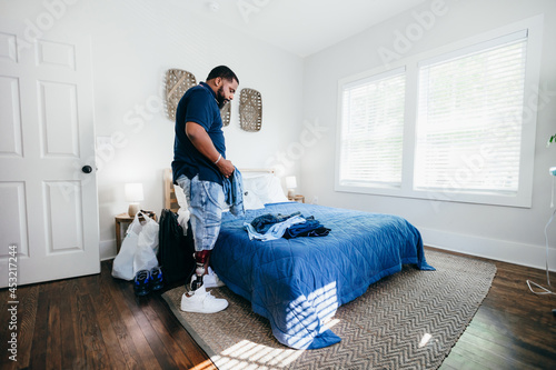 African American man with prosthetic leg doing chores, laundry, at home