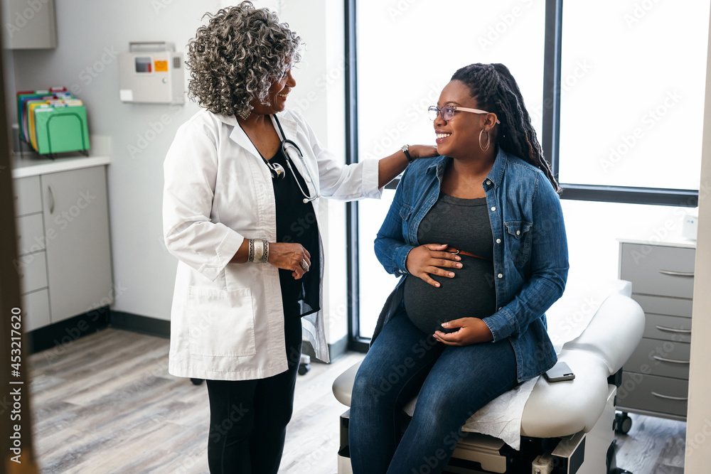 Black female doctor speaks with female pregnant patient Stock Photo ...