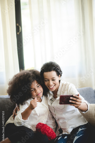 Cheerful young mother takin...