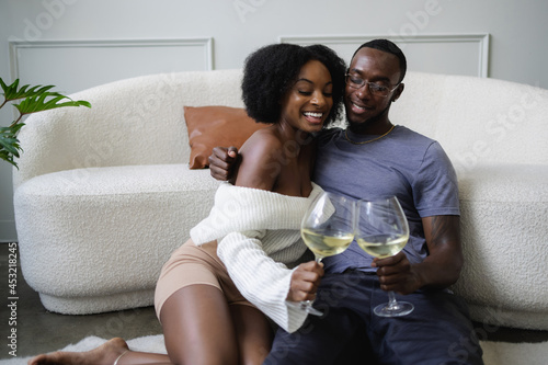 Smiling couple cuddling and toast celebrating buying new home together