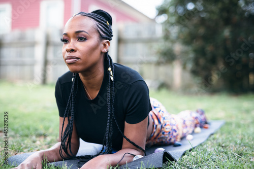 Black woman practicing yoga in backyard, healthy lifestyle