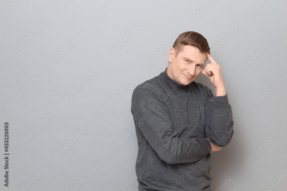 Portrait of happy mature man touching temple with hand and smiling Portrait of happy mature man touching temple with hand and smiling