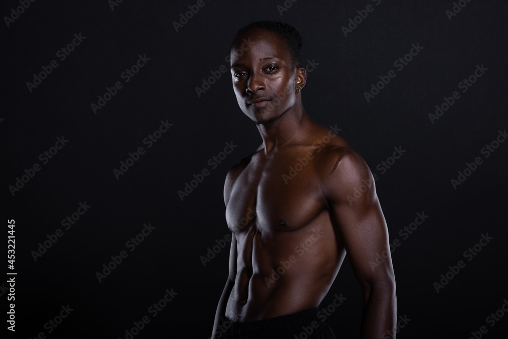 Fit African American man with muscles posing in studio Fit African American man with muscles posing in studio