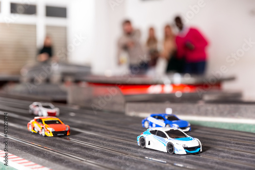 Models of race cars on the track in playroom, selective focus on car