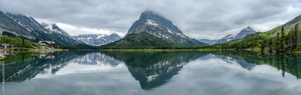 Spring Mountain Lake - A stormy Spring evening view of Swiftcurrent Lake, with Mt. Grinnell towering at west shore and Mt. Wilbur disappeared in thick clouds, Glacier National Park, Montana, USA.
