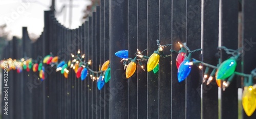 Selective Focus of Christmas Lights on a Metal Fence