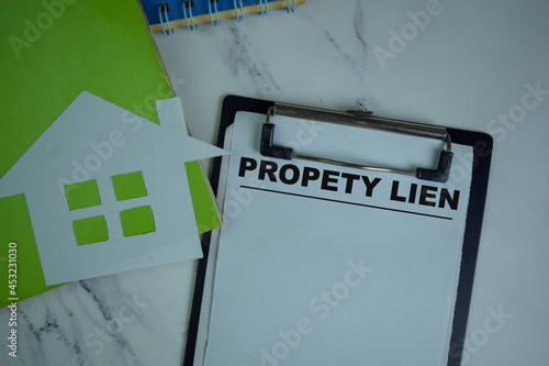 Property Lien write on a paperwork isolated on Wooden Table. photo