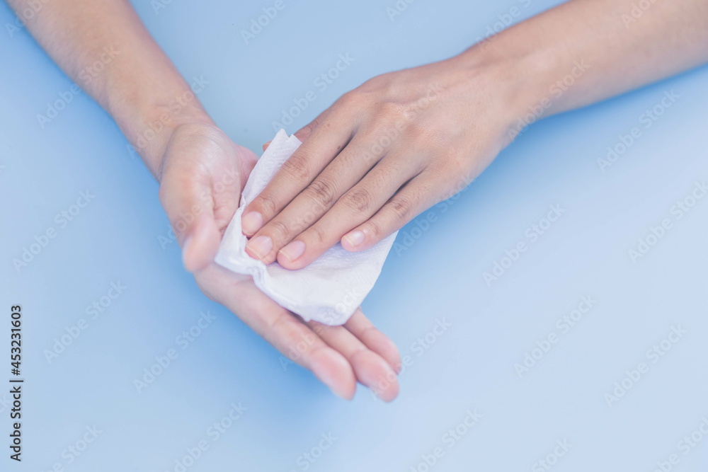 Obraz premium Woman wiping sweat on her hands. Woman suffers from Hyperhidrosis on hand.