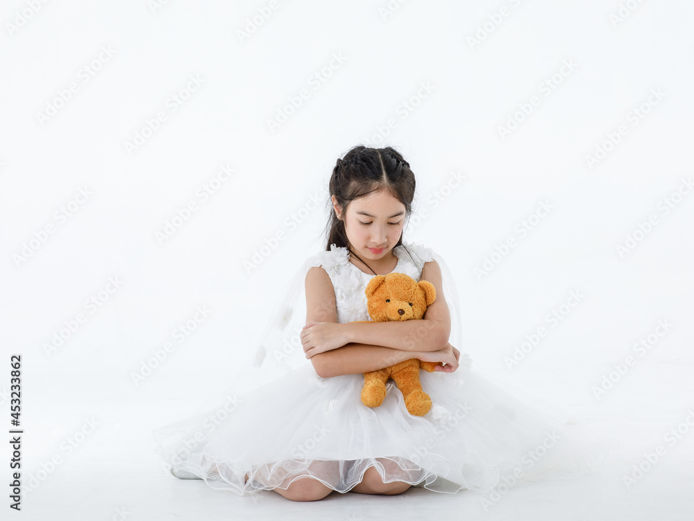 Portrait close up isolated studio shot of Asian pretty girl wears white princess long rose flower dress fashion costume look at camera sit hug fluffy orange teddy bear doll in front white background Portrait close up isolated studio shot of Asian pretty girl wears white princess long rose flower dress fashion costume look at camera sit hug fluffy orange teddy bear doll in front white background