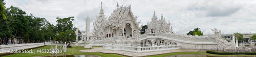 Chiang Rai, THAILAND - July 20, 2021: famous white temple, panoramic photo during the day without people, snow-white structure, greenery, pond                               