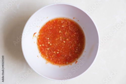 Spicy red chilli sauce in a bowl. Top view