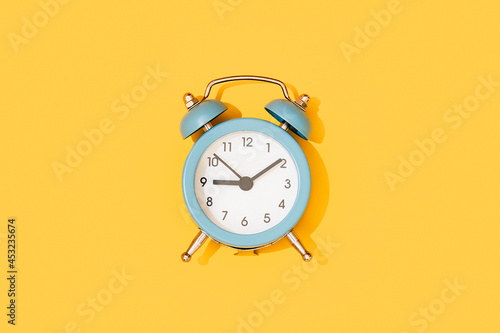 Alarm. Blue clock on a yellow background.