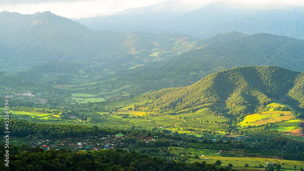 Plan timelaps the light of the sunset shining through the green mountains and rural village. Plan timelaps the light of the sunset shining through the green mountains and rural village.