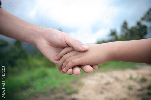 Parent holding hand of a little child © surachat