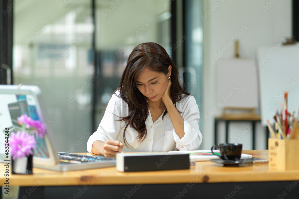 Serious focused graphic designer woman working on digital tablet Serious focused graphic designer woman working on digital tablet
