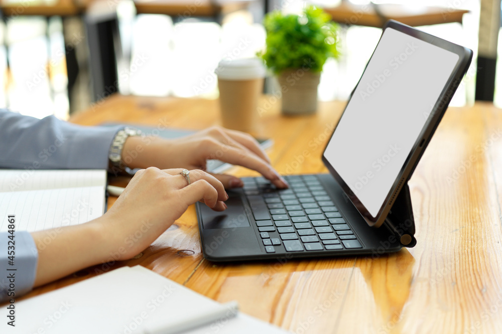 Closeup hands, businesswoman typing on portable tablet keyboard Closeup hands, businesswoman typing on portable tablet keyboard
