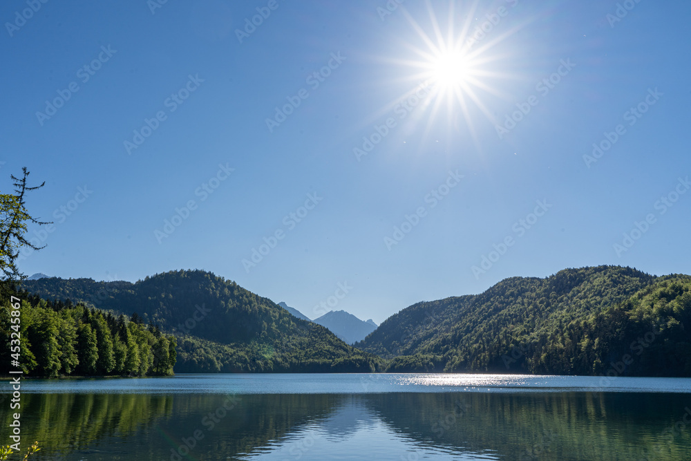 Sonnenstrahlen über dem Alpsee im Allgäu in Bayern
