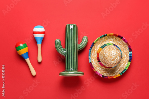 Mexican maracas, cactus and sombrero on color background